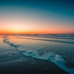 A beautiful view of the foamy waves on the beach under the sunset captured in Domburg, Netherlands